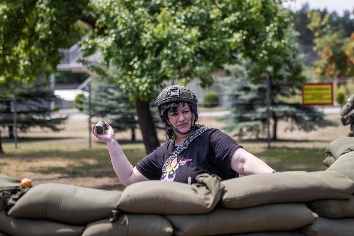 Civilians learn how to throw imitation grenades during a military training day in Poland.