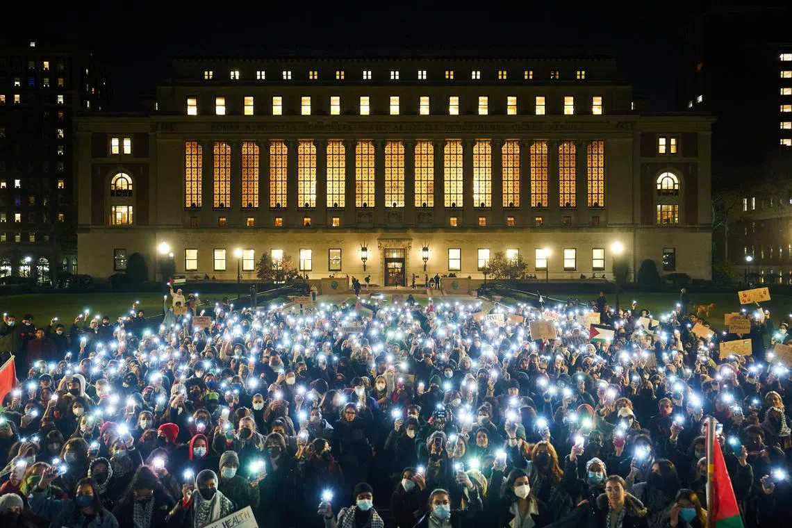 Students wave their phone lights at a demonstration over how universities are handling free speech and antisemitism.