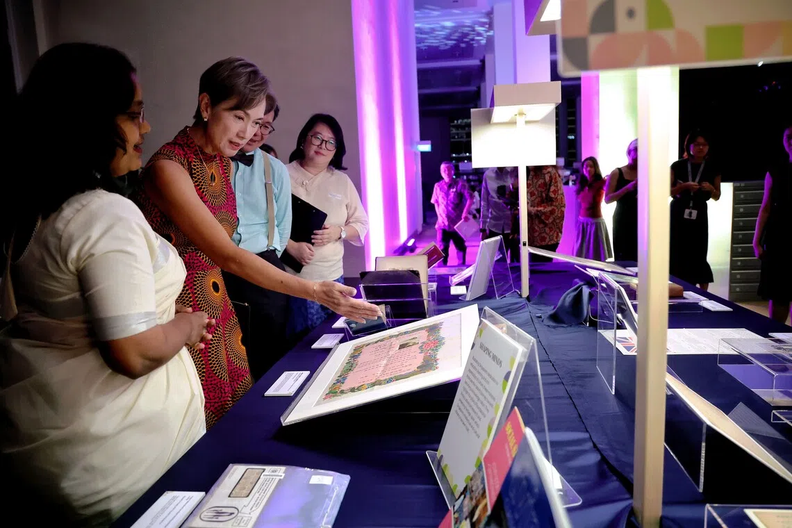 Minister for Digital Development and Information Josephine Teo viewing a marriage certificate of Mr Kok Yew Loong and Ms Wong Pui Wah from 1933.
