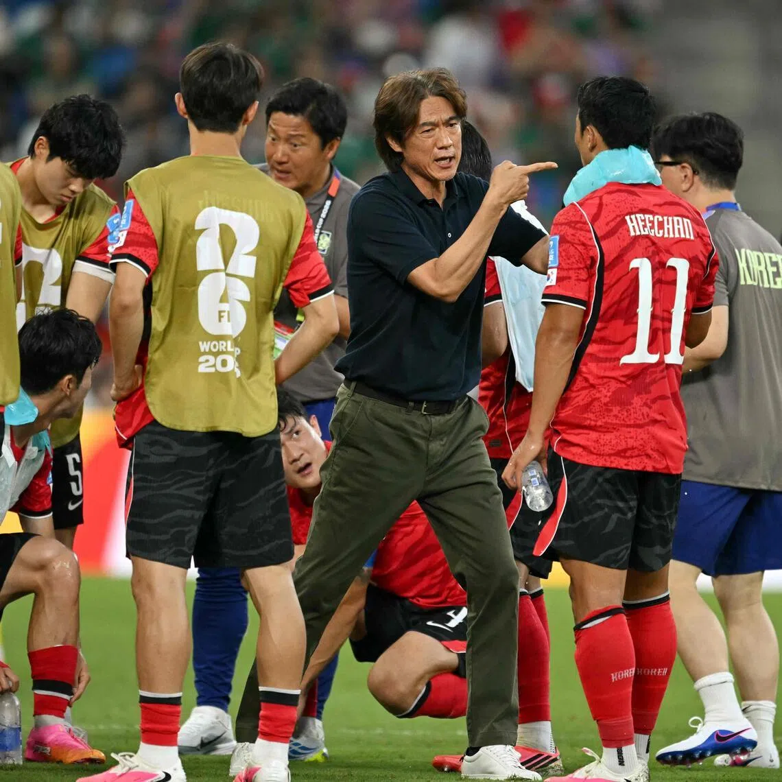 South Korea's head coach Hong Myung-bo talks to his players  during a hydration break of the 2026 World Cup Group A football match between South Africa and South Korea at the Monterrey Stadium in Guadalupe, Mexico, on June 24, 2026.  (Photo by Yuri CORTEZ / AFP)