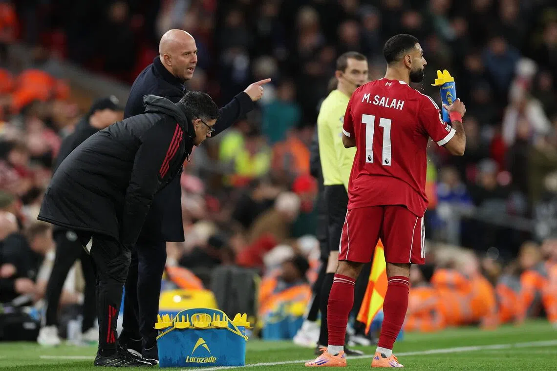 Liverpool's Mohamed Salah during a break in play against Brighton and Hove Albion as manager Arne Slot looks on.