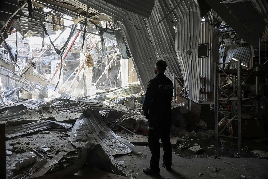 A police officer standing at the site of a terminal of the Nova Poshta (New Post) delivery service damaged during a Russian drone strike, amid Russia's attack on Ukraine, in Odesa, Ukraine, May 1, 2025.
