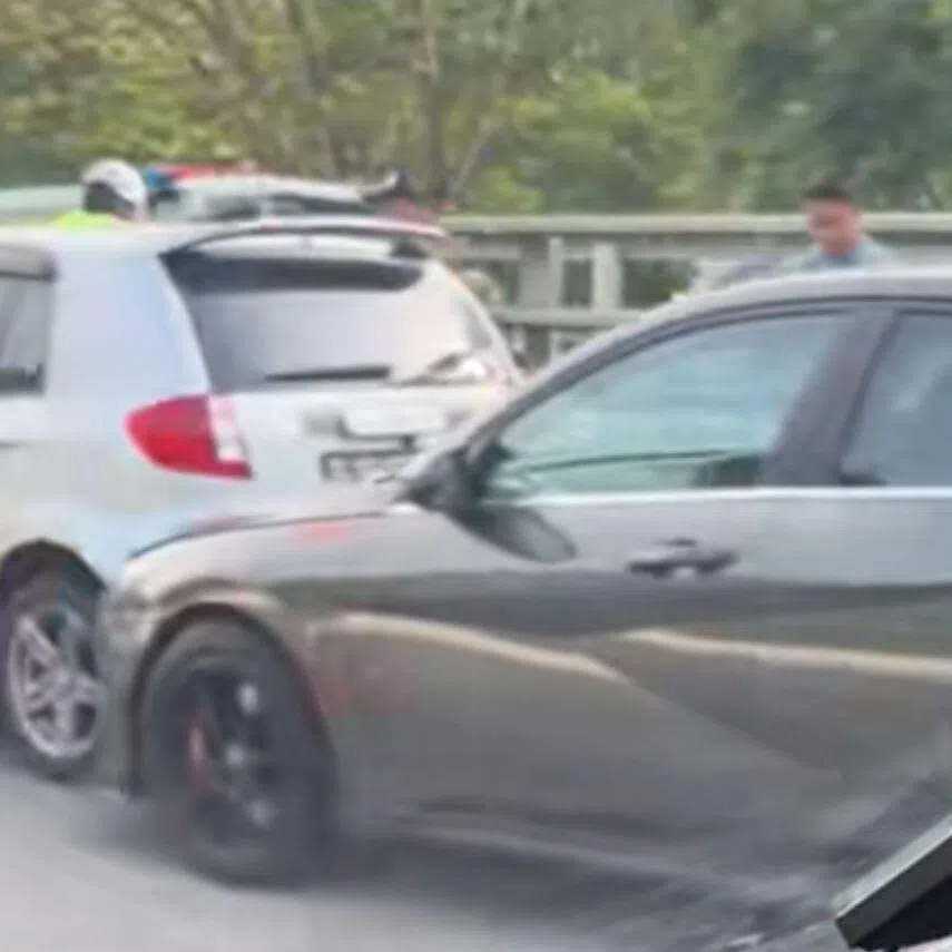 Several vehicles and two motorcycles are seen on a cordoned lane.