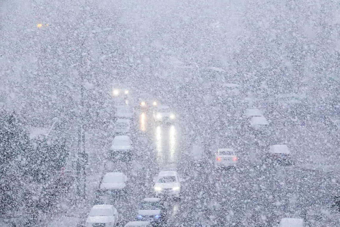 Cars making their way during snowfall in Dalian, in China's northeastern Liaoning province on Nov 23, 2023.