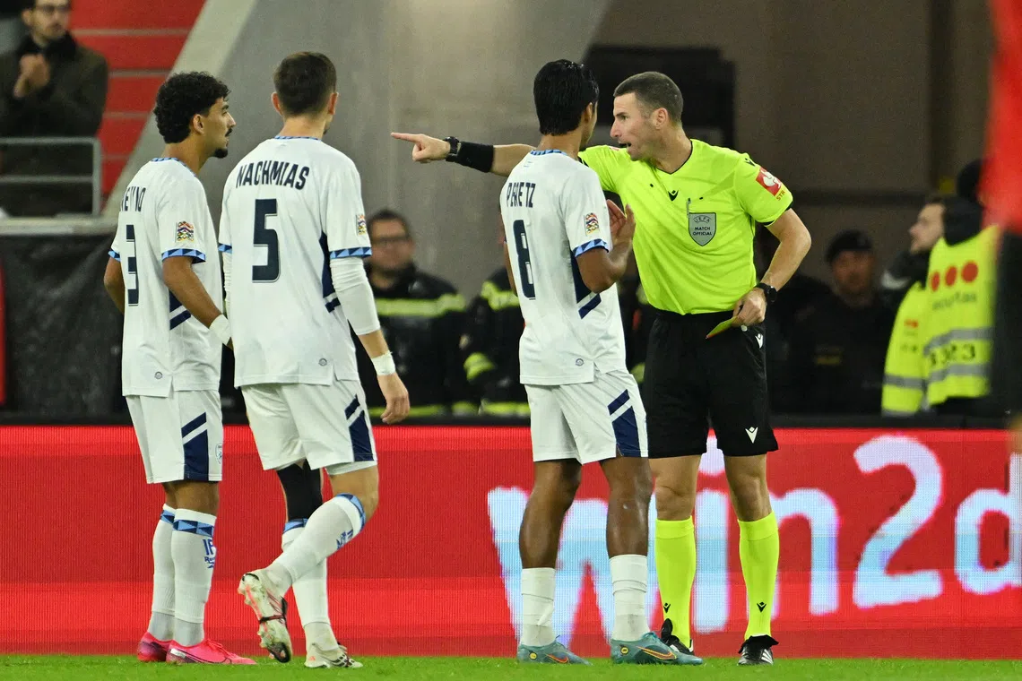 Soccer Football - Nations League - Group G - Austria v Israel - Raiffeisen Arena, Linz, Austria - September 24, 2026 Israel's Roy Revivo, Idan Nachmias and Dor Peretz remonstrate with referee Georgi Kabakov after Israel's Sayed Abu Farchi is shown a red card REUTERS/Elisabeth Mandl