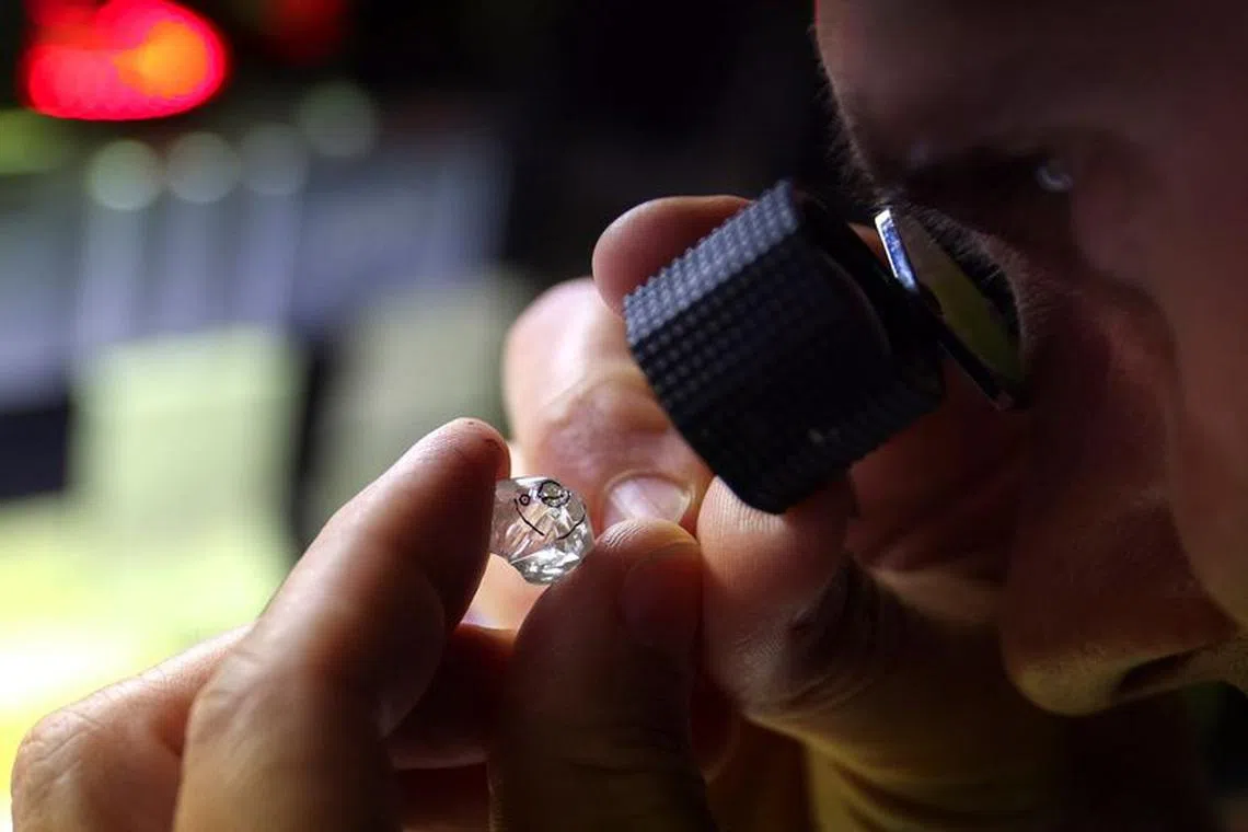 An employee looks at a rough diamond at \"Flanders Manufacturing\", as the G7 weighs a ban on Russian diamond imports to reduce revenues for Moscow's war in Ukraine, Antwerp, Belgium, October 30, 2023. REUTERS/Johanna Geron/File Photo
