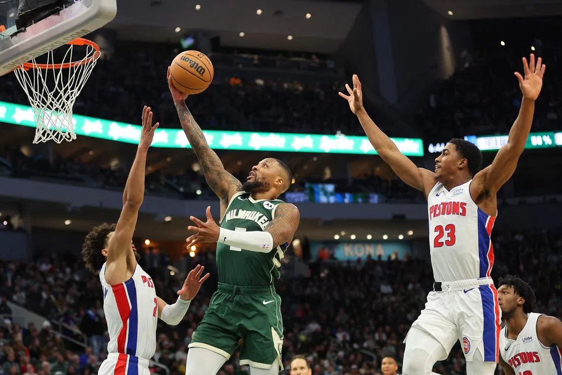 Damian Lillard of the Milwaukee Bucks drives to the basket against Cade Cunningham of the Detroit Pistons during the second half at Fiserv Forum.