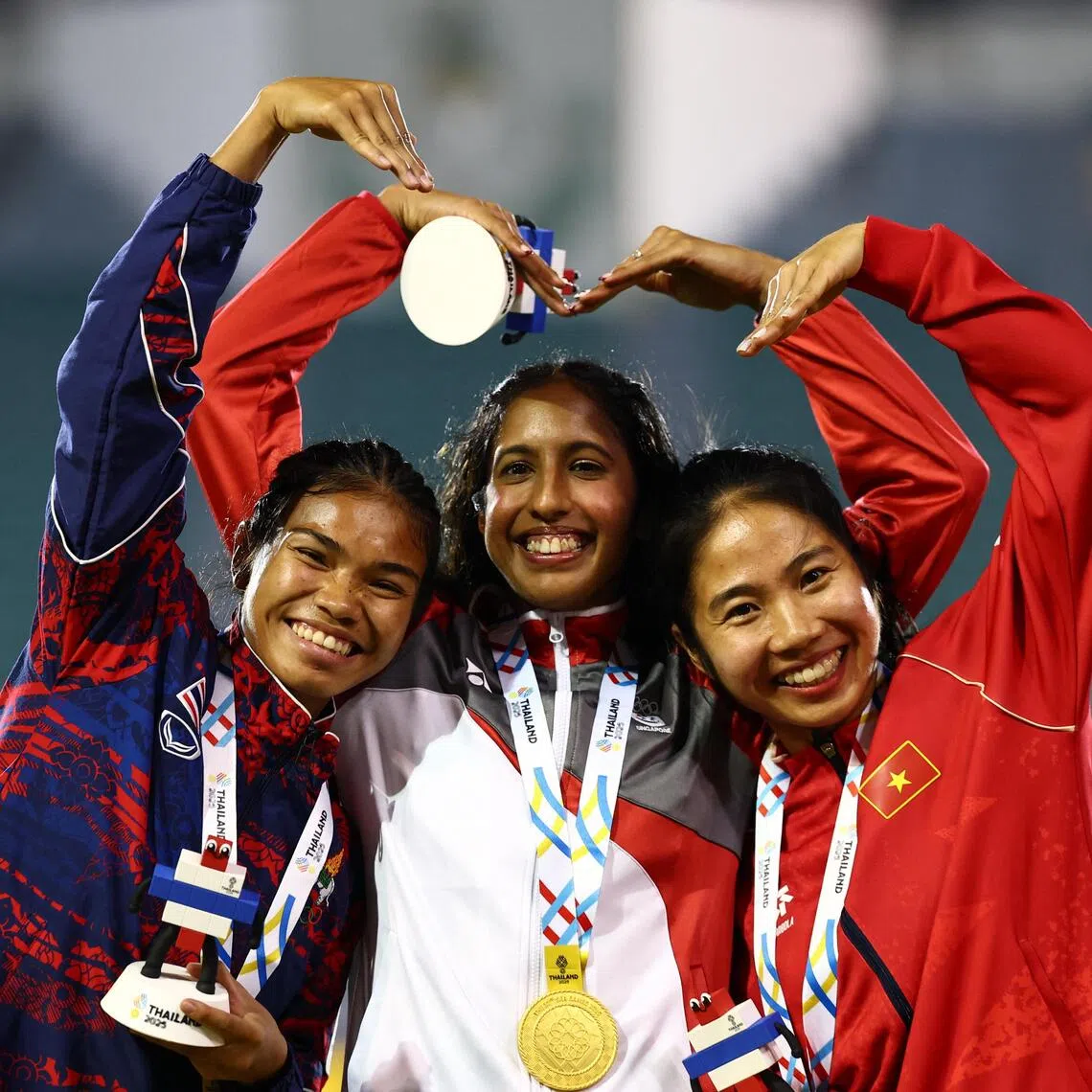 Gold medallist Singapore's Shanti Pereira celebrates on the podium during the women's 100m final medal ceremony with silver medallist Thailand's Jirapat Khanonta and bronze medallist Vietnam's Ha Thi Thu.