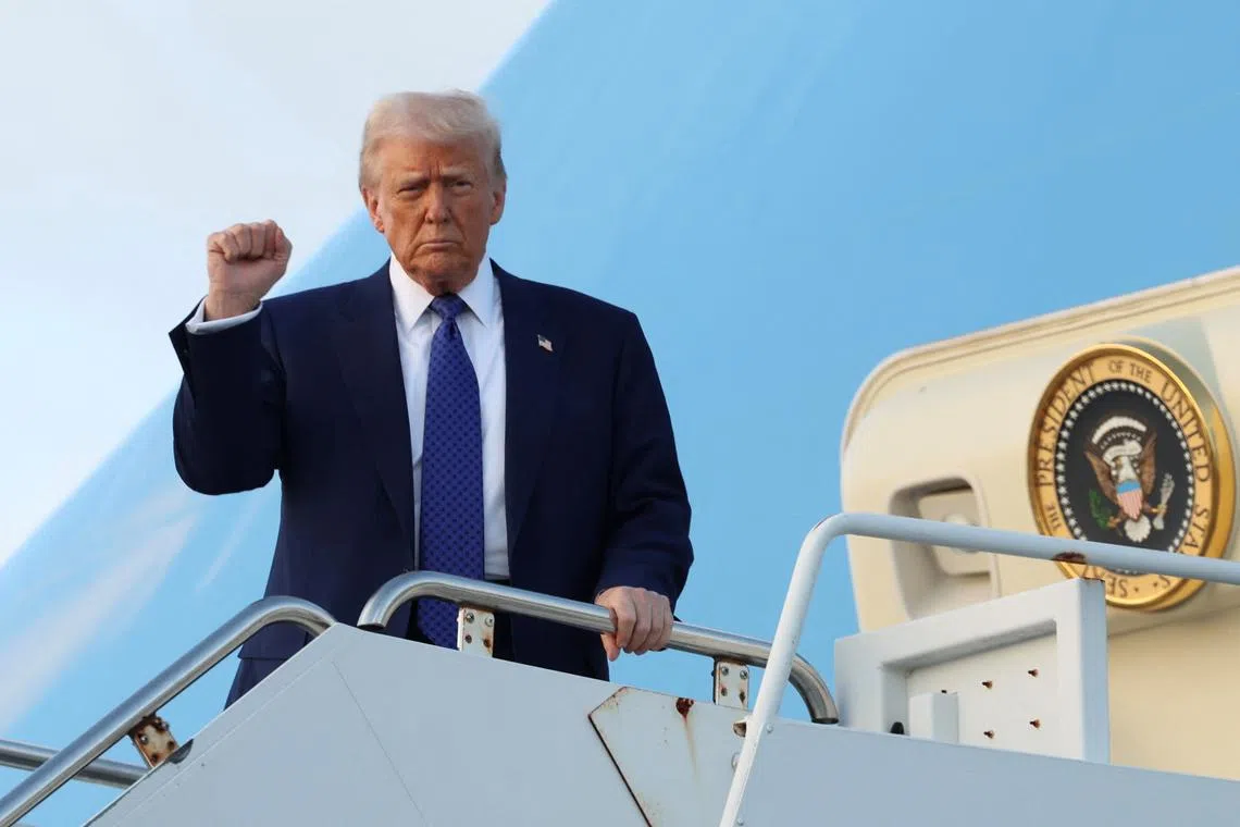 U.S. President Donald Trump raises his fist upon arrival in West Palm Beach, Florida, U.S., February 14, 2025. REUTERS/Kevin Lamarque