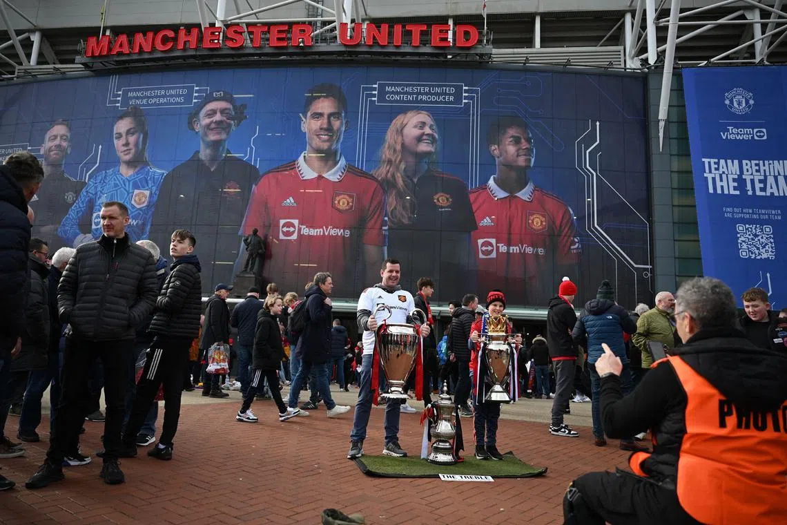 Fans posing for photos outside of Old Trafford stadium in Manchester, England, ahead of the English Premier League match between United and Leicester City, on February 19, 2023. 