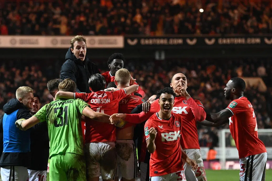 Charlton's Scottish defender Sam Lavelle celebrating with teammates after scoring the winning penalty during the English League Cup fourth round football match between Charlton Athletic and Brighton & Hove Albion, at The Valley stadium on December 21.