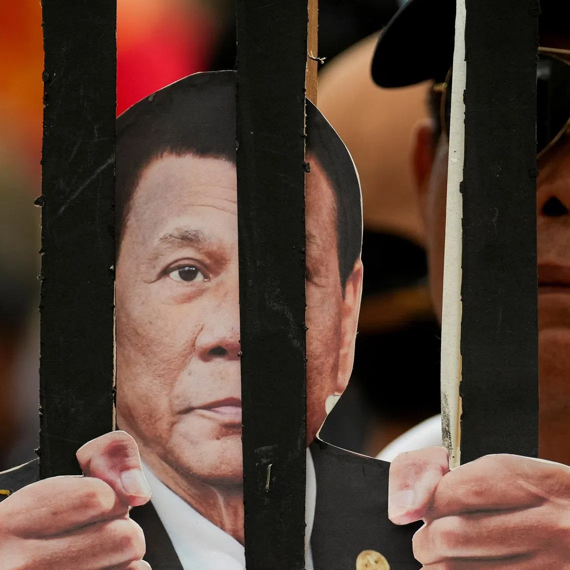 A man carries a placard with a cutout of an image of former Philippine President Rodrigo Duterte behind bars, during the 80th birthday of Duterte, who remains in ICC custody for war crimes allegations, in Manila, Philippines, March 28, 2025. 