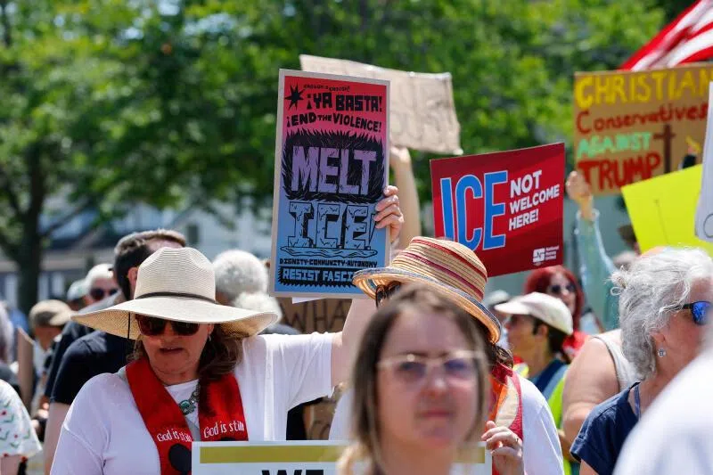 People hold placards as they take part in a protest at Mechanics Park after a shooting involving U.S. Immigration and Customs Enforcement (ICE) in Biddeford, Maine, U.S. July 13, 2026. REUTERS/CJ Gunther