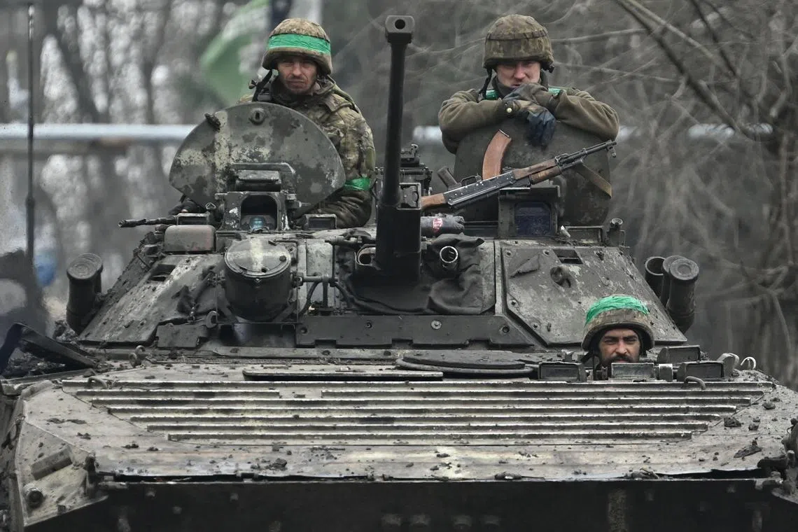 Ukrainian servicemen ride on a BMP infantry fighting vehicle on a road near Bakhmut, in Ukraine's Donetsk region.