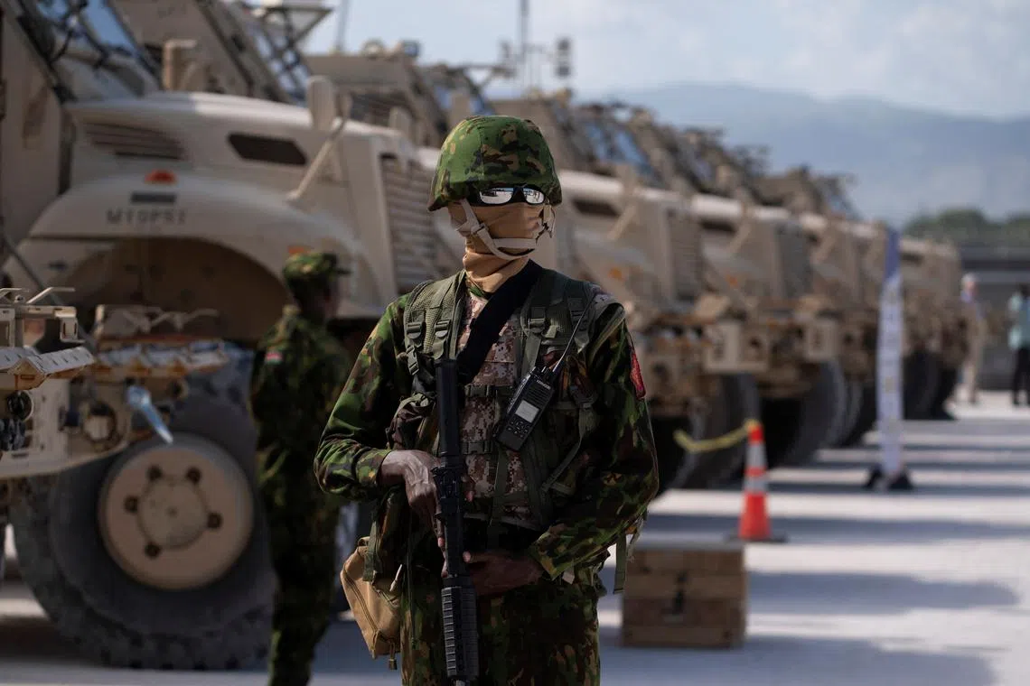 FILE PHOTO: A Kenyan police officer stands next to a row of anti-mine armoured vehicles in Port-au-Prince, Haiti, on July 22, 2024.  Roberto Schmidt/Pool via REUTERS/File Photo
