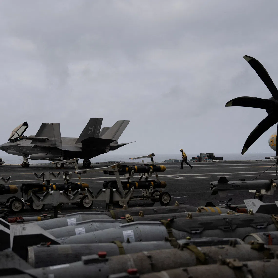 A U.S. Navy sailor runs across the flight deck of the USS George Washington in the Arabian Sea, September 11, 2026. The aircraft carrier, capable of carrying more than 5,000 personnel, is enforcing a U.S. naval blockade against Iran and providing cover for commercial vessels transiting the Strait of Hormuz. REUTERS/Ed Ou