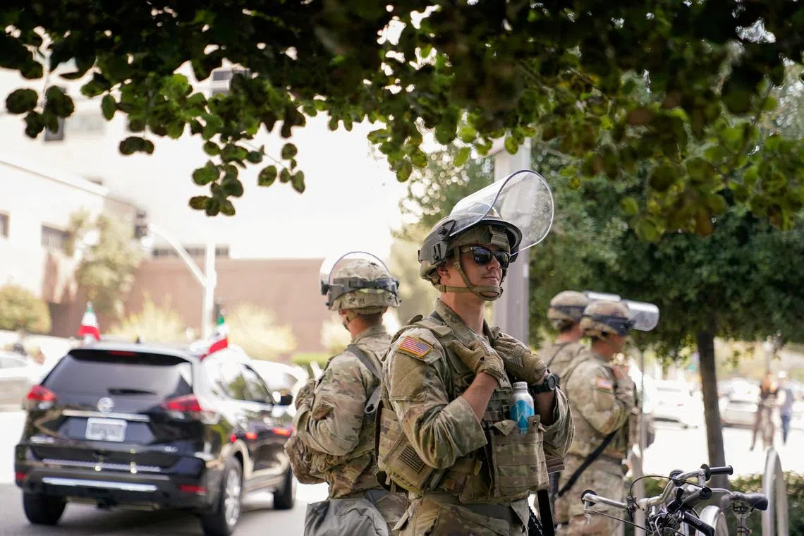 FILE PHOTO: U.S. Marines stand watch as people protest against U.S. President Donald Trump's policies and federal immigration sweeps during a No Kings Day demonstration in Los Angeles, California, U.S., June 14, 2025.  REUTERS/David Ryder/File Photo