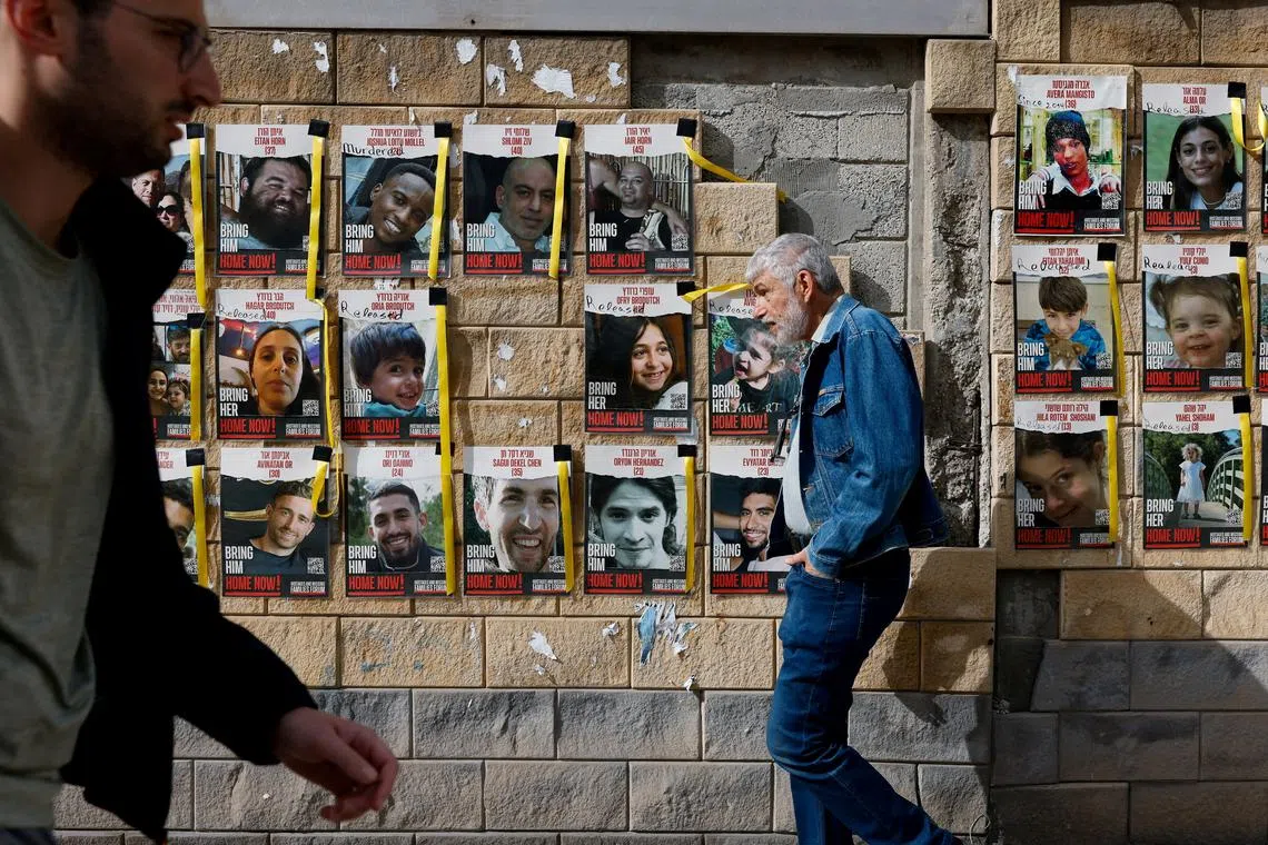 FILE PHOTO: People walk past placards with photos of hostages kidnapped in the deadly October 7 attack on Israel by the Palestinian Islamist group Hamas from Gaza, in Tel Aviv, Israel March 17, 2024. REUTERS/Carlos Garcia Rawlins/File Photo
