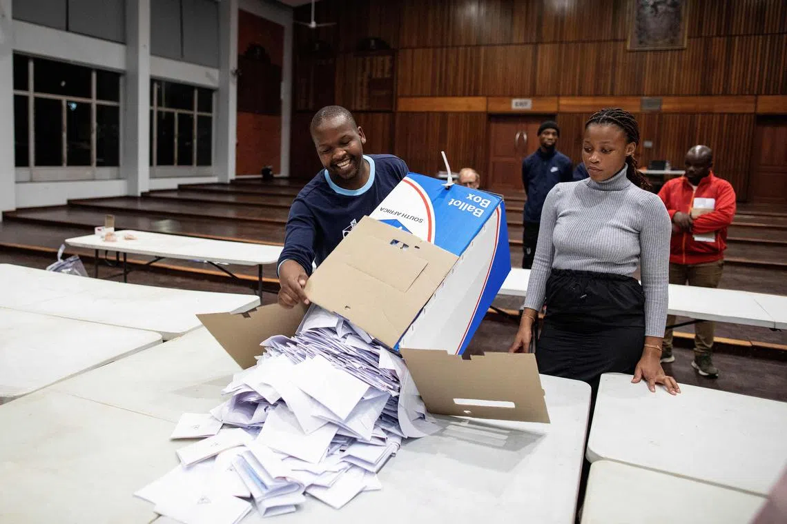 Electoral Commission of South Africa (IEC) officials empty a ballot box during the vote counting process at the Norwood school voting station in Durban on May 29, 2024, during South Africa’s general election. South African voters queued -- many of them for hours -- to cast their ballots on May 29, 2024 in a landmark general election that has left the ruling ANC fighting to protect its three-decade-long exclusive grip on power. (Photo by GIANLUIGI GUERCIA / AFP)