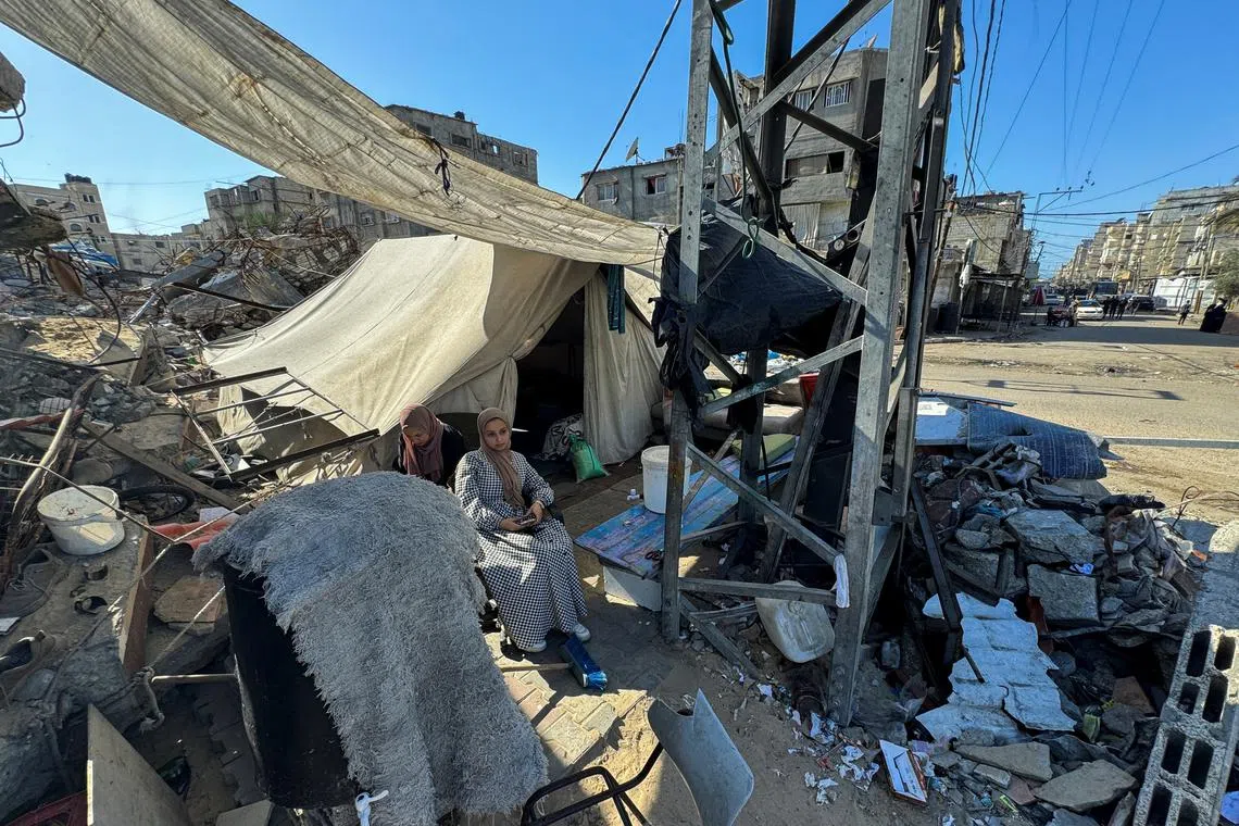 Displaced Palestinians, who fled their house due to Israel's military offensive, sit outside their tent, in Rafah, in the southern Gaza Strip May 13, 2024. REUTERS/Mohammed Salem