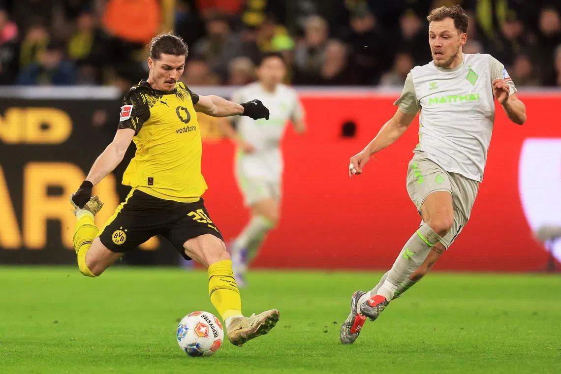 Soccer Football - Bundesliga - Borussia Dortmund v Werder Bremen - Signal Iduna Park, Dortmund, Germany - January 13, 2026 Borussia Dortmund's Marcel Sabitzer in action with Werder Bremen's Jens Stage REUTERS/Leon Kuegeler