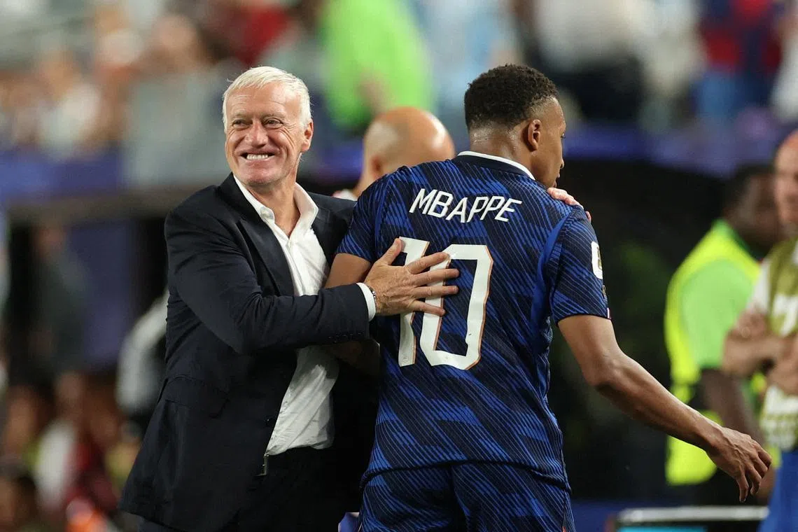 France coach Didier Deschamps embraces Kylian Mbappe as he leaves the pitch after being substituted.