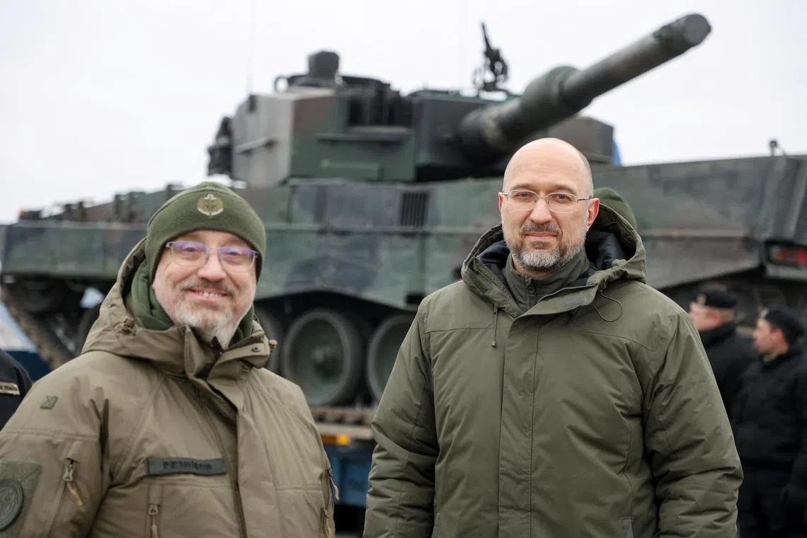 Ukrainian Prime Minister Denys Shmyhal and Defence Minister Oleksii Reznikov stand next to the first Leopard 2 tanks delivered from Poland, on Feb 24, 2023.