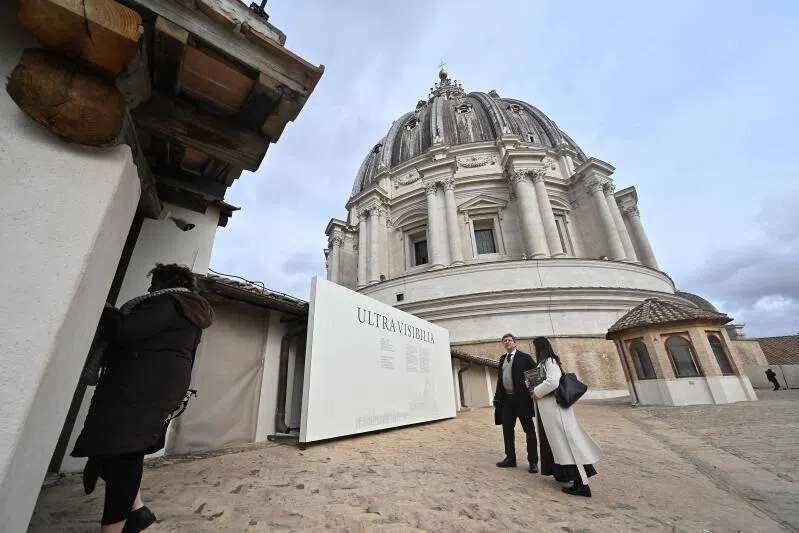 People stand on a terrace of St Peter's Basilica before a press preview of the exhibition "Beyond the Visible" project, in the Vatican on Feb 16, 2026.