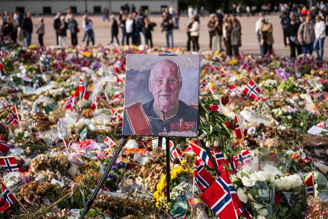A painted portrait of Norway’s King Harald V is displayed among flowers and Norwegian flags at a makeshift memorial outside the Royal Palace in Oslo on Sept 8.