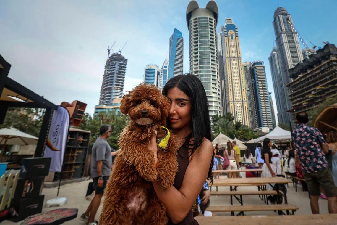 A woman poses for a picture with her dog during the Barkfest dog festival at Barasti Beach in Dubai on April 4. 