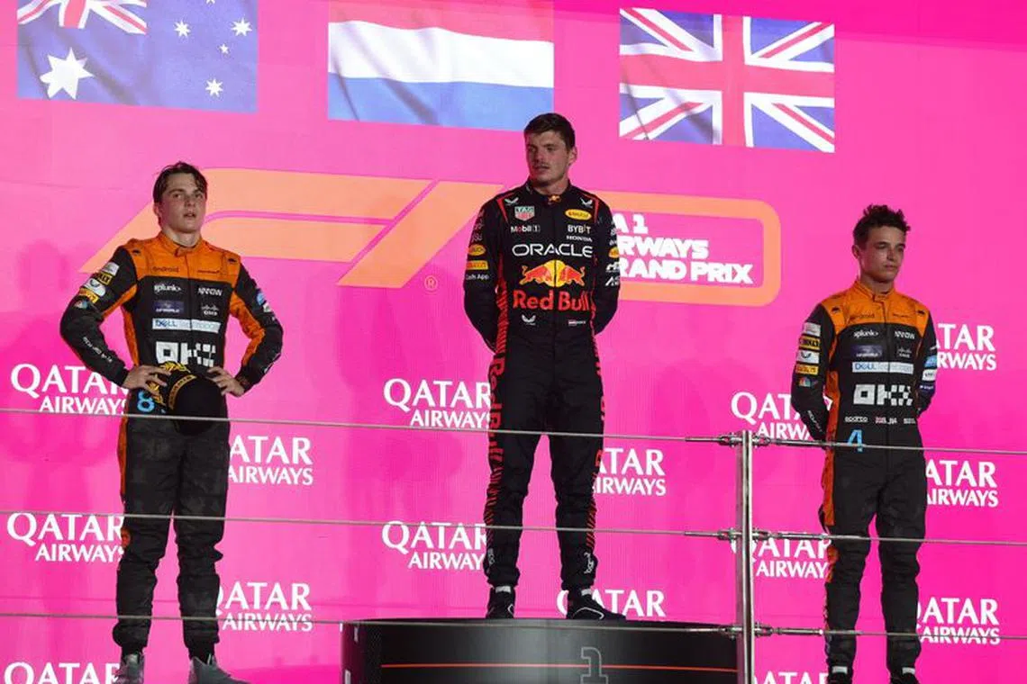 Formula One F1 - Qatar Grand Prix - Lusail International Circuit, Lusail, Qatar - October 8, 2023 Second placed Oscar Piastri of McLaren, first placed Max Verstappen of Red Bull and third placed Lando Norris of McLaren on the podium during the trophy presentation after the race REUTERS/Ibraheem Al Omari