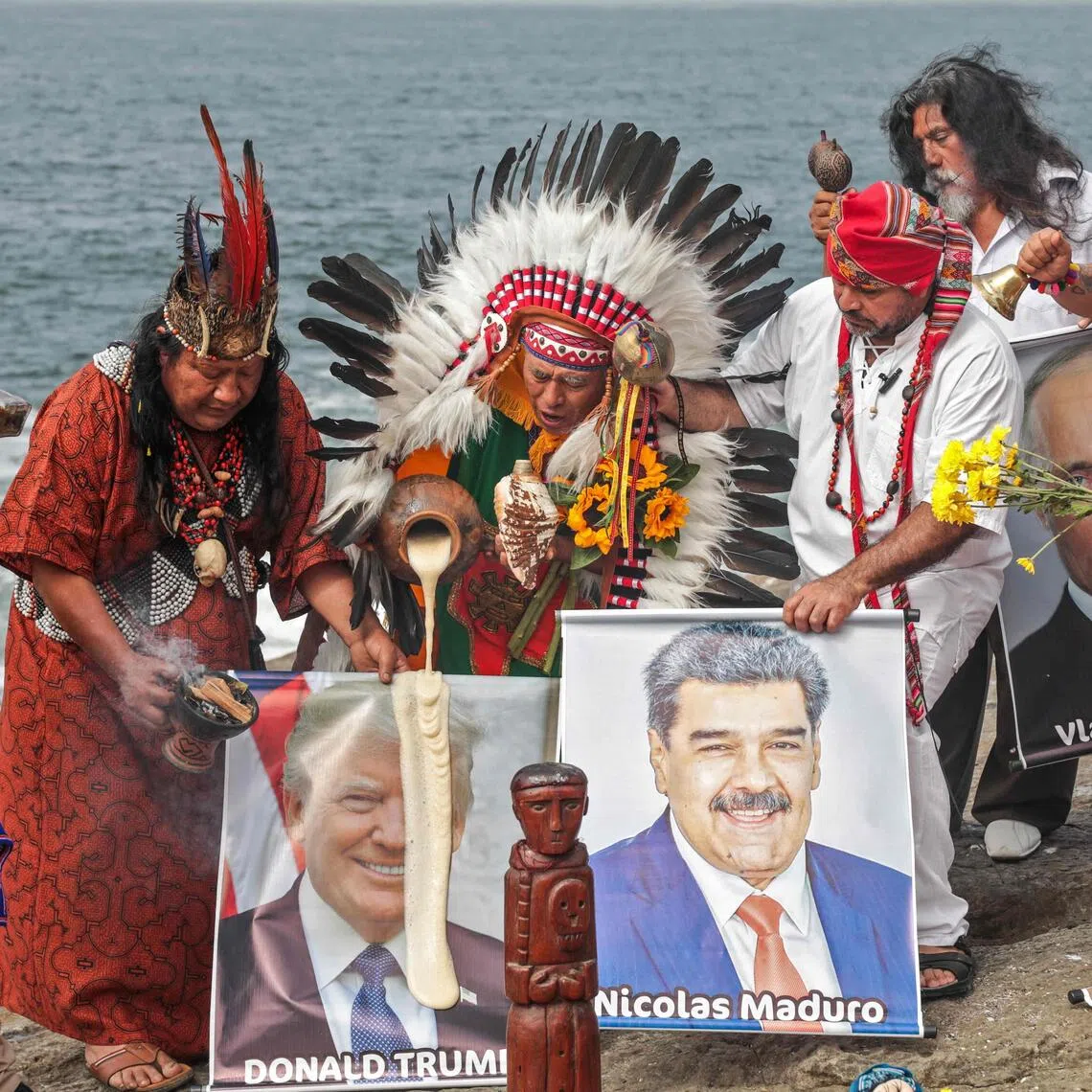 A group of shamans and healers hold images of US President Donald Trump and Venezuelan President Nicolas Maduro while performing end-of-year ritual in front of the sea in Chorrillos, Peru.