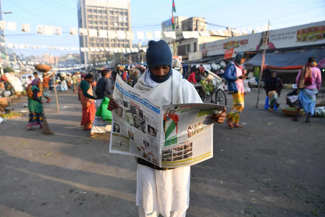 A Bangladeshi man reads a newspaper carrying headlines of the general election results in Dhaka on December 31, 2018. - Bangladesh Prime Minister Sheikh Hasina has secured a fourth term with a landslide victory in polls the opposition slammed as "farcical" over claims of vote-rigging, and clashes between rival supporters that killed at least 17 people. (Photo by Indranil MUKHERJEE / AFP)