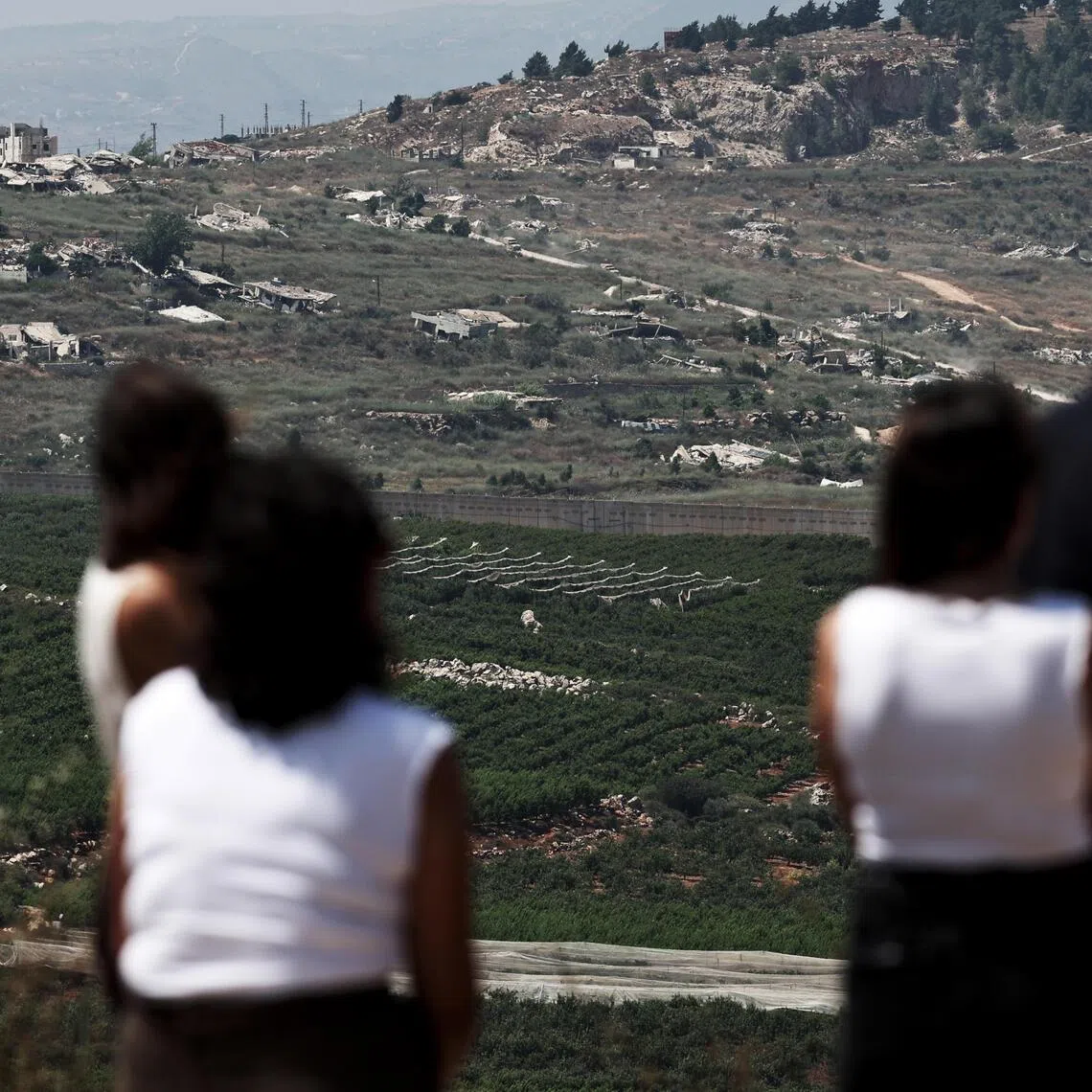 People watching the Lebanese side of the border from Metula, in the Upper Galilee in northern Israel, on June 28, amid an Israel-Lebanon ceasefire.