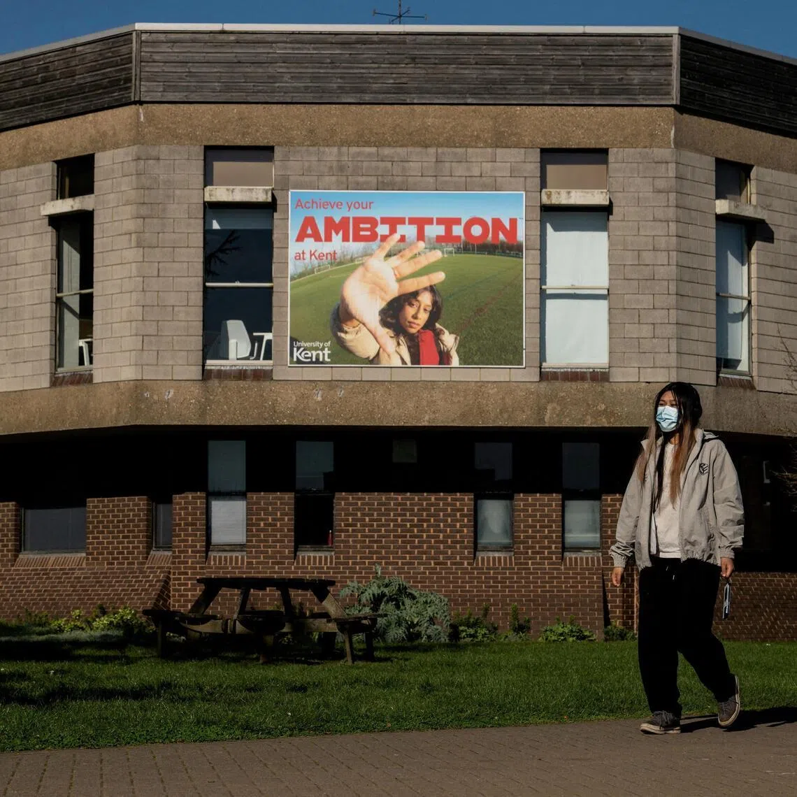 A student wears a protective mask as they walk through the University of Kent campus, following an outbreak of meningitis cases.