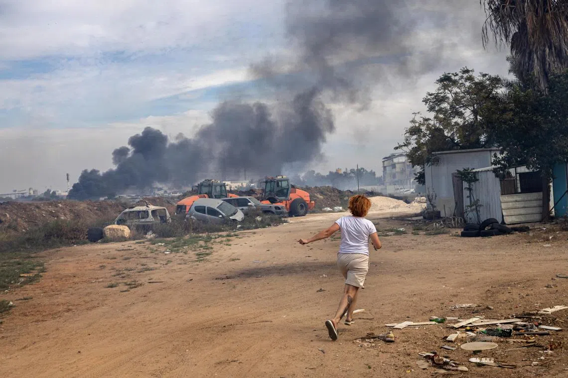 Ms Evgenia Simanovich runs to her home's reinforced concrete shelter, moments after rocket sirens sounded in Ashkelon, Israel.