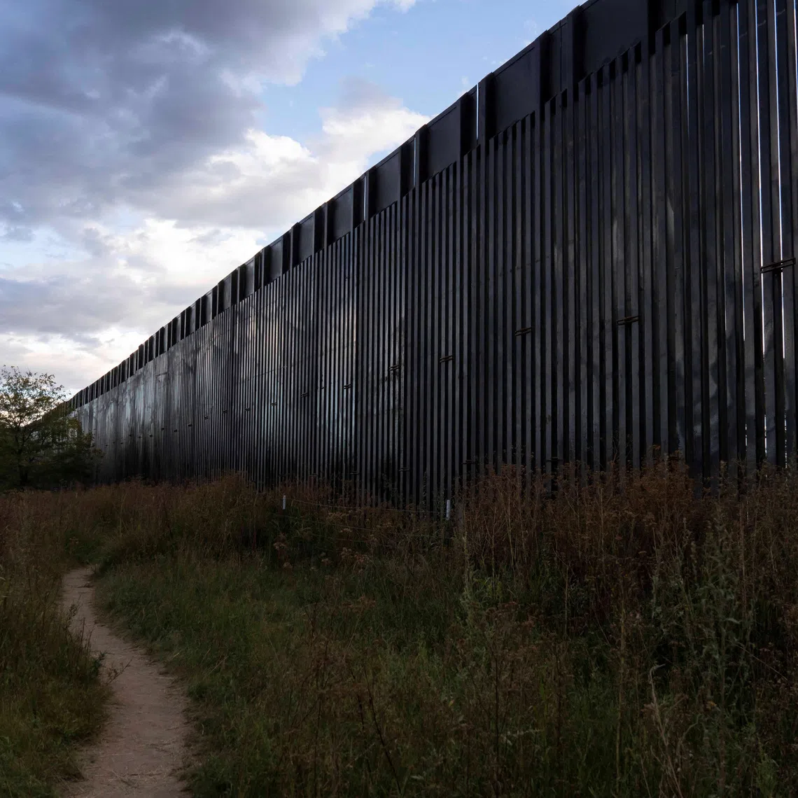 A footpath winds into the distance beside a section of the US-Mexico border fence constructed earlier in the day in Lochiel, Arizona, US October 8, 2026.  REUTERS/Rebecca Noble/File Photo