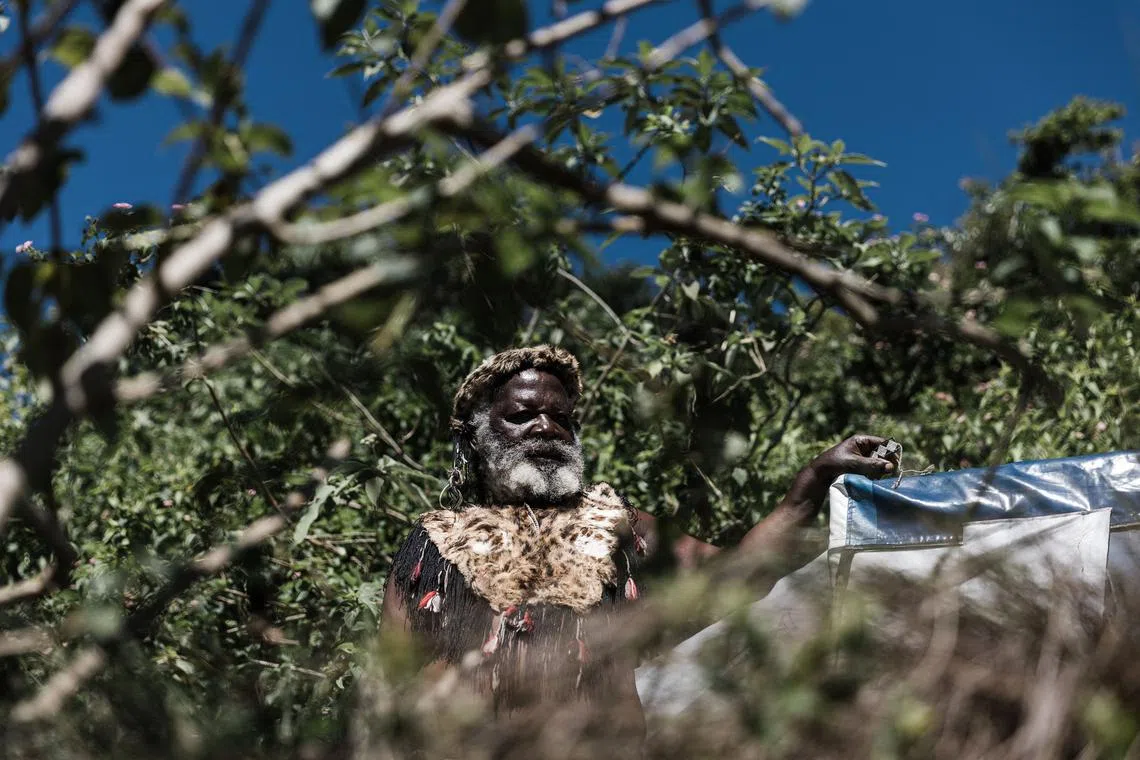 Dressed in traditional Zulu attire a devotee of the Nazareth Baptist Church, from the Ekuphakameni group, also known as the Shembe Church, gestures on the Nhlangakazi Holy Mountain in Ndwedwe 85km north of Durban, on Jan 8, 2023.