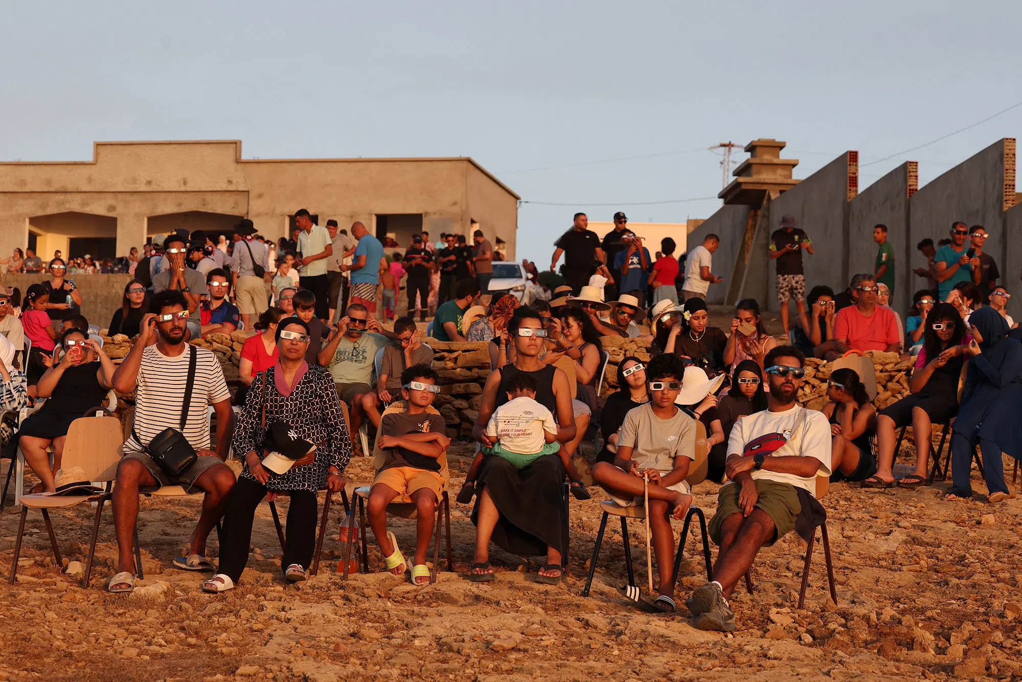 epa13165320 People watch a partial solar eclipse in Sidi Mechreg, Bizerte Governorate, Tunisia, 12 August 2026. A total solar eclipse swept across parts of Europe and the North Atlantic, with the path of totality crossing Greenland, Iceland, Spain and a small section of northeastern Portugal, while surrounding areas experienced a partial solar eclipse, according to the European Space Agency (ESA). EPA/MOHAMED MESSARA