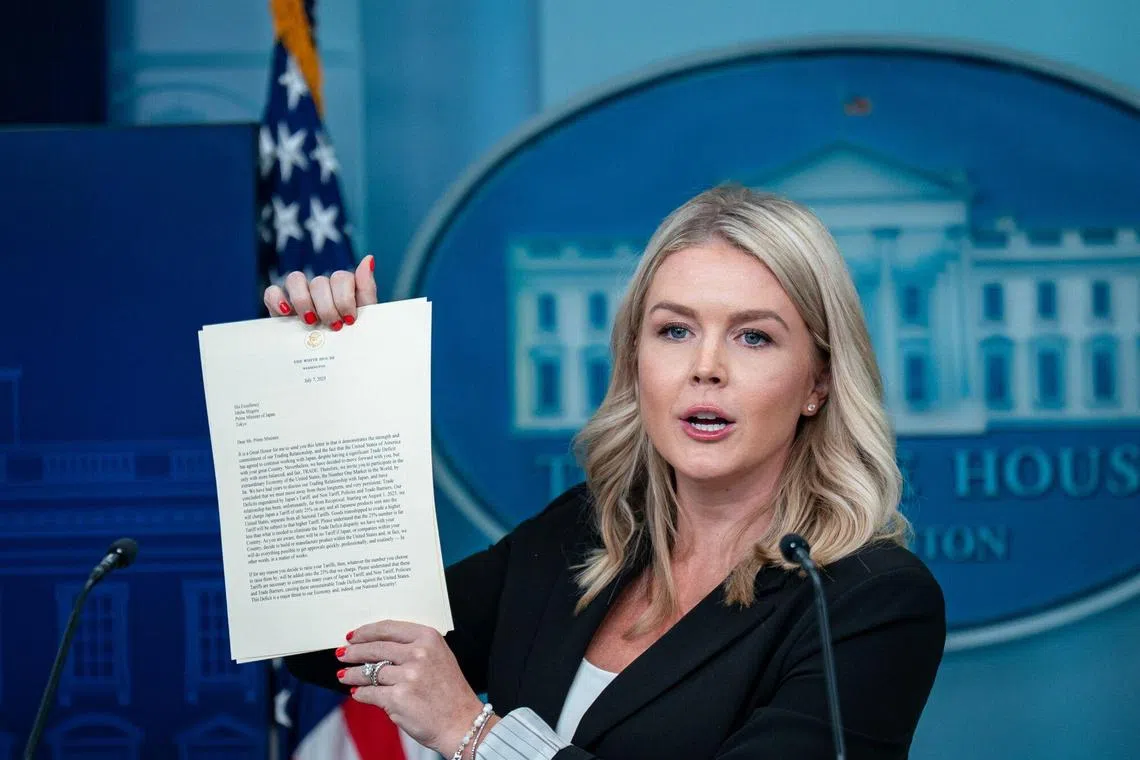 White House press secretary Karoline Leavitt holding up a trade letter sent to Japan during a news conference on July 7.