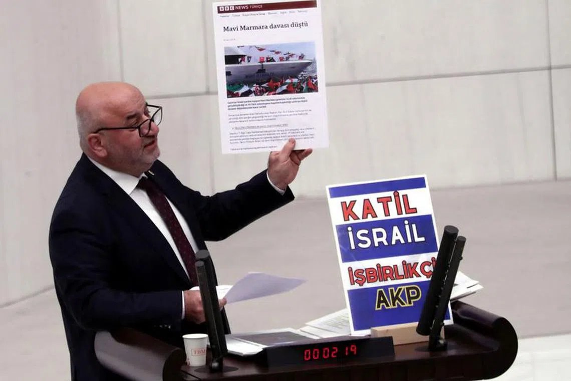 Turkey's opposition Felicity Party (Saadet) lawmaker Hasan Bitmez makes a speech at a stand with a placard, criticizing the government's policy towards Israel, at the Turkish parliament in Ankara, Turkey December 12, 2023. The placard reads: \"Murderer Israel, collaborator AK Party\". REUTERS/Stringer