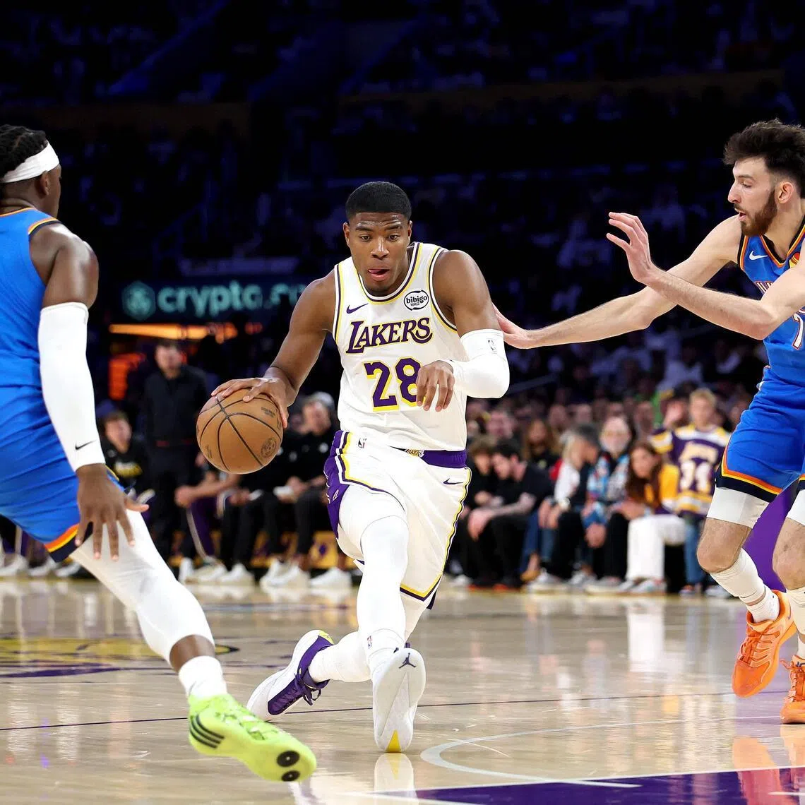 Los Angeles Lakers forward Rui Hachimura (in white) drives to the basket against Oklahoma City Thunder's Luguentz Dort (No. 5) and Chet Holmgren (No. 7) in Game Three of their NBA Western Conference Playoffs semi-finals series in May 9.