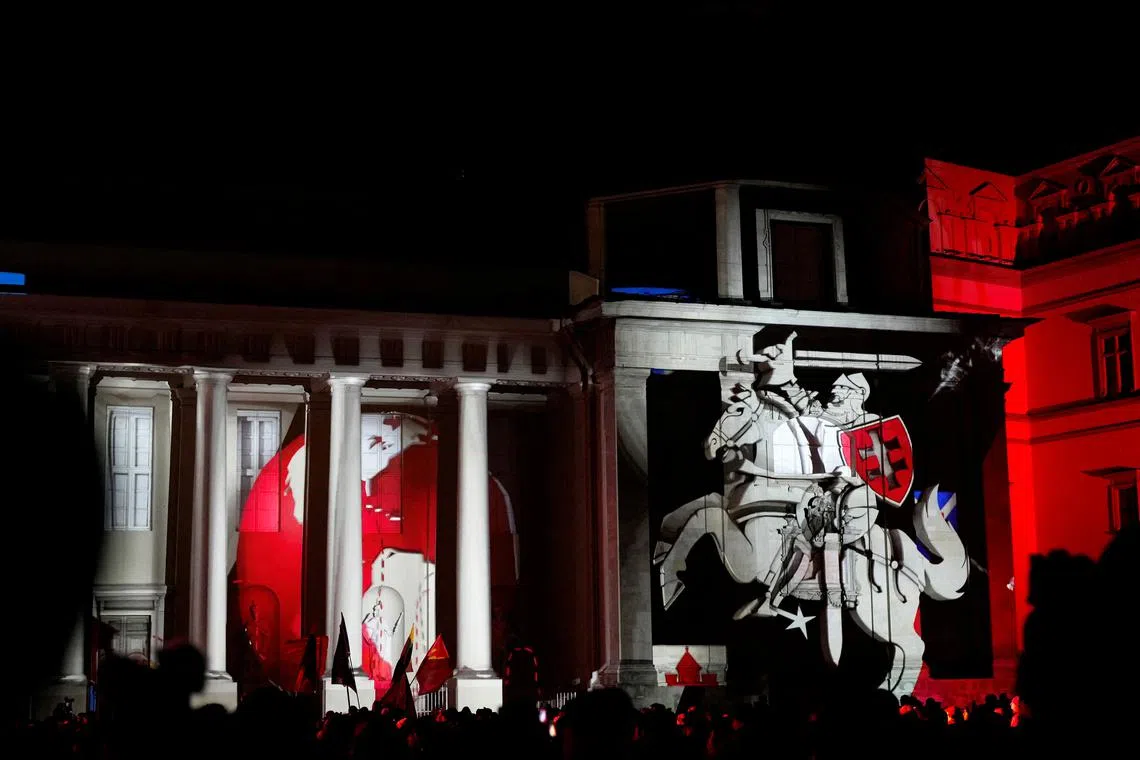 People watch light illumination during Lithuanian capital's 700th anniversary celebration with the festival of lights in Vilnius, Lithuania Jan 25, 2023. 