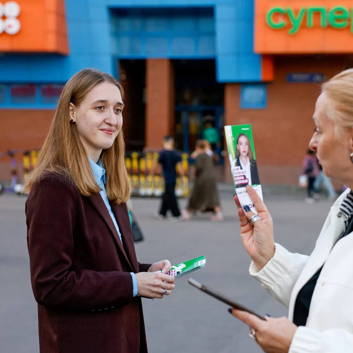 Polina Lermant, 24, a candidate for Russia's liberal Yabloko party running in a single-mandate constituency in the upcoming parliamentary election, hands out flyers to passers-by on a street in Moscow, Russia, September 3, 2026. REUTERS/Yulia Morozova