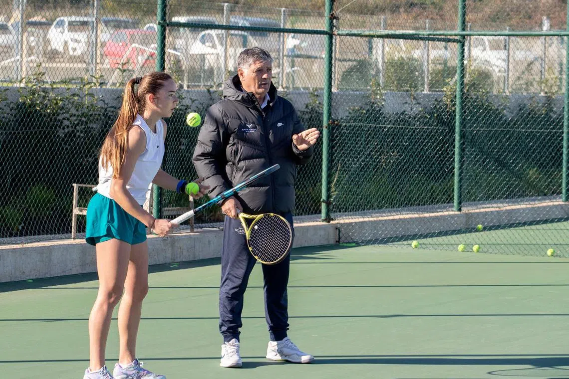 Coach Toni Nadal talks to a student during a training session on an outdoor court at Rafa Nadal Academy in Manacor.