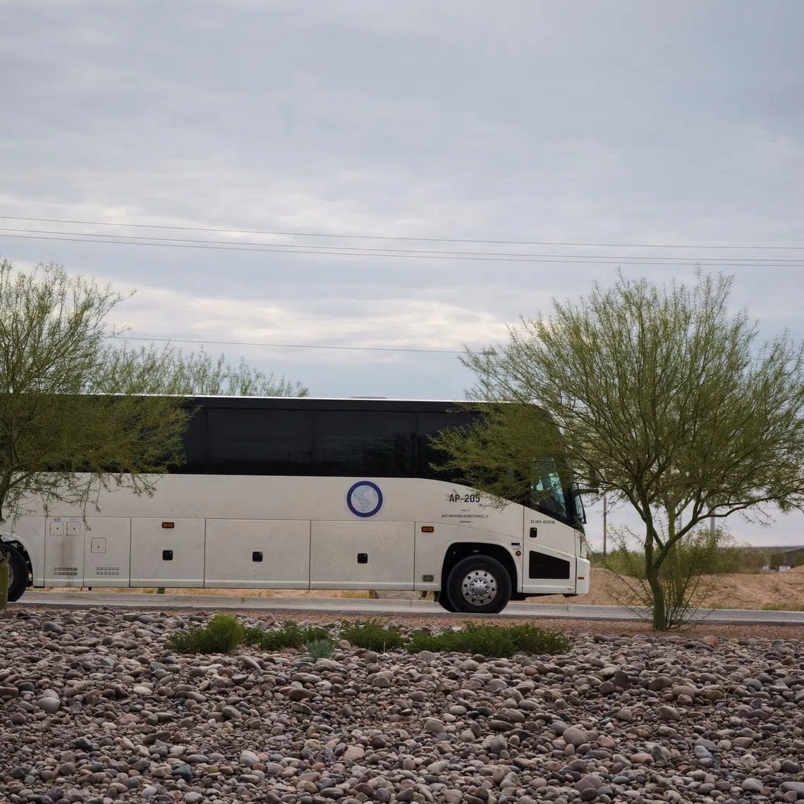 FILE PHOTO: A bus used to transport detainees of Immigration and Customs Enforcement exits Camp East Montana, the new ICE detention facility being built to house up to 5,000 migrants, which is under construction at Fort Bliss in El Paso, Texas, U.S., August 17, 2025.  REUTERS/Paul Ratje/File Photo
