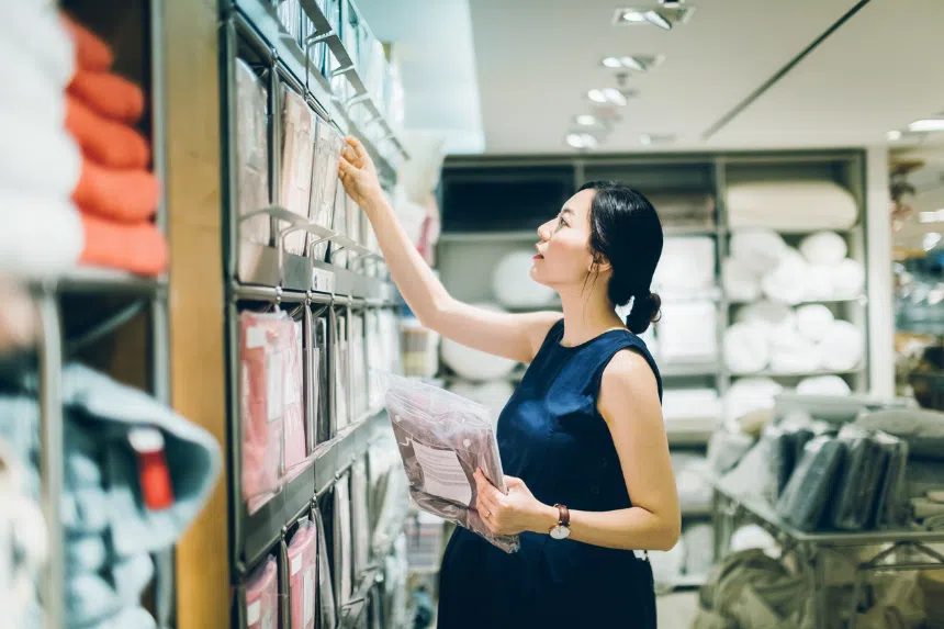 Best bedsheets in Singapore: Woman choosing bedsheets in shop