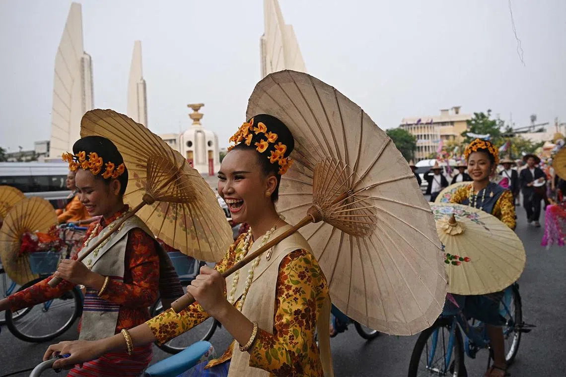 Performers riding bicycles during a parade to celebrate the upcoming Thai New Year, locally known as Songkran, in Bangkok on April 11, 2024. 