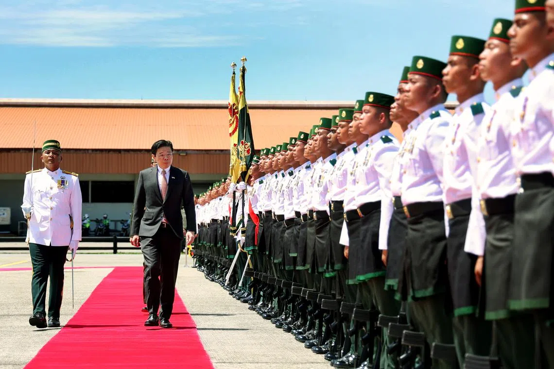 Prime Minister Lawrence Wong inspecting the guard of honour at a welcome ceremony at Brunei International Airport on June 11.