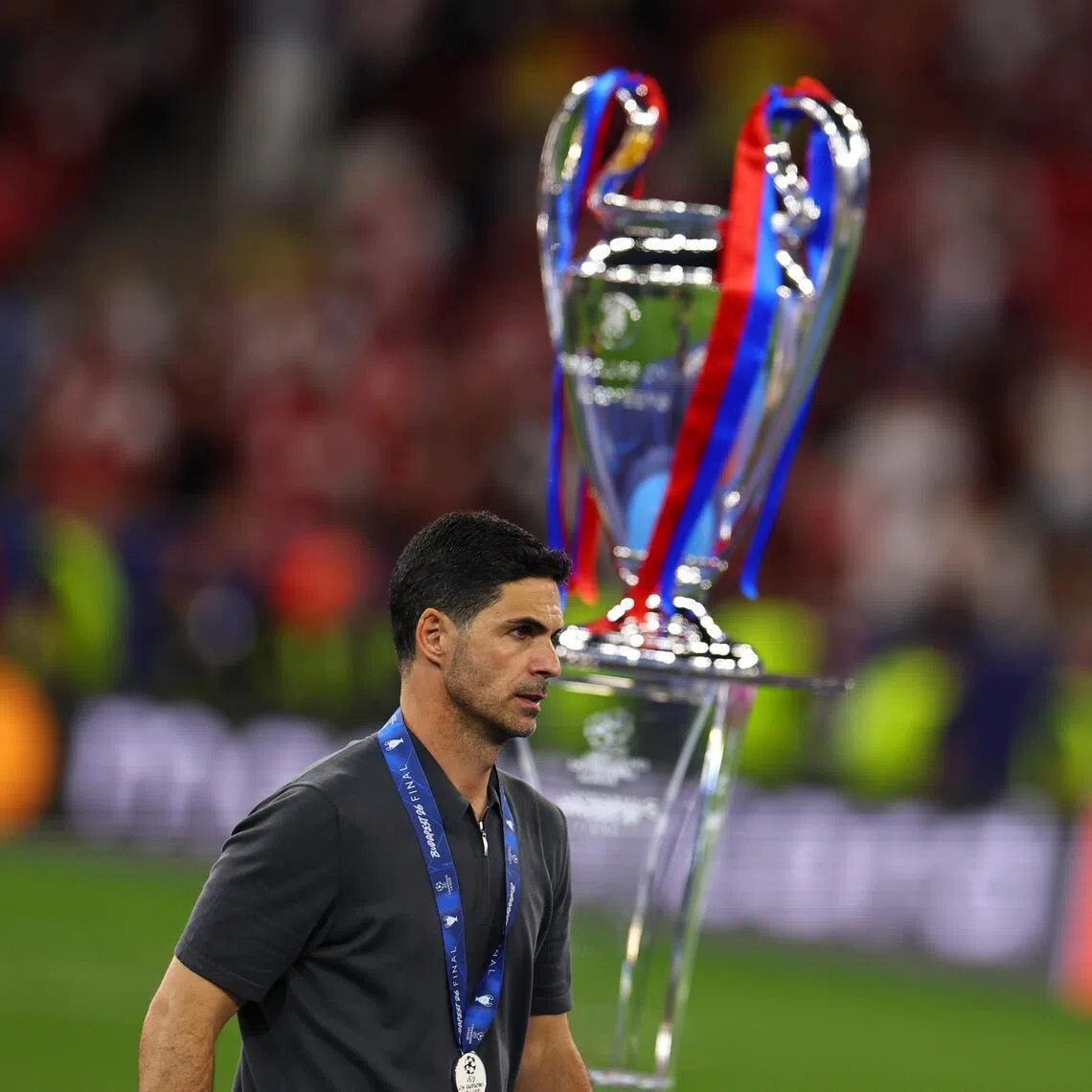 Arsenal manager Mikel Arteta walks past the trophy after losing the Champions League final against Paris Saint-Germain.